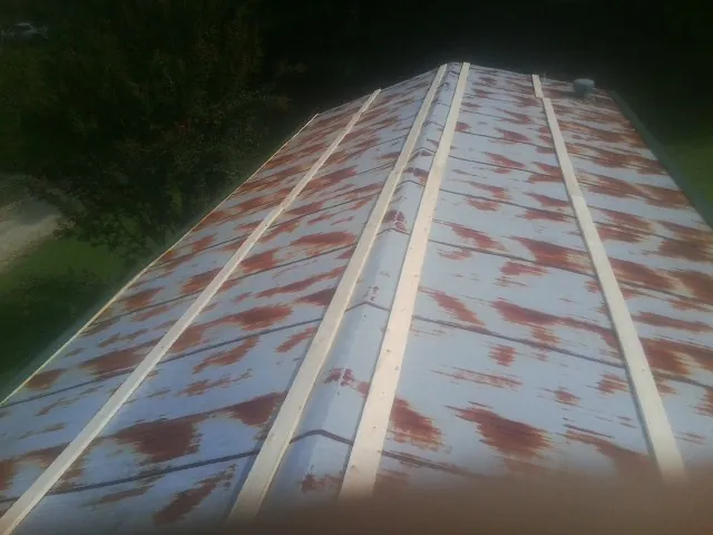 Rusted metal roof panels with new wood purlins before replacement — Storm Damage Roof Repair in Haleyville by Roofing Brothers