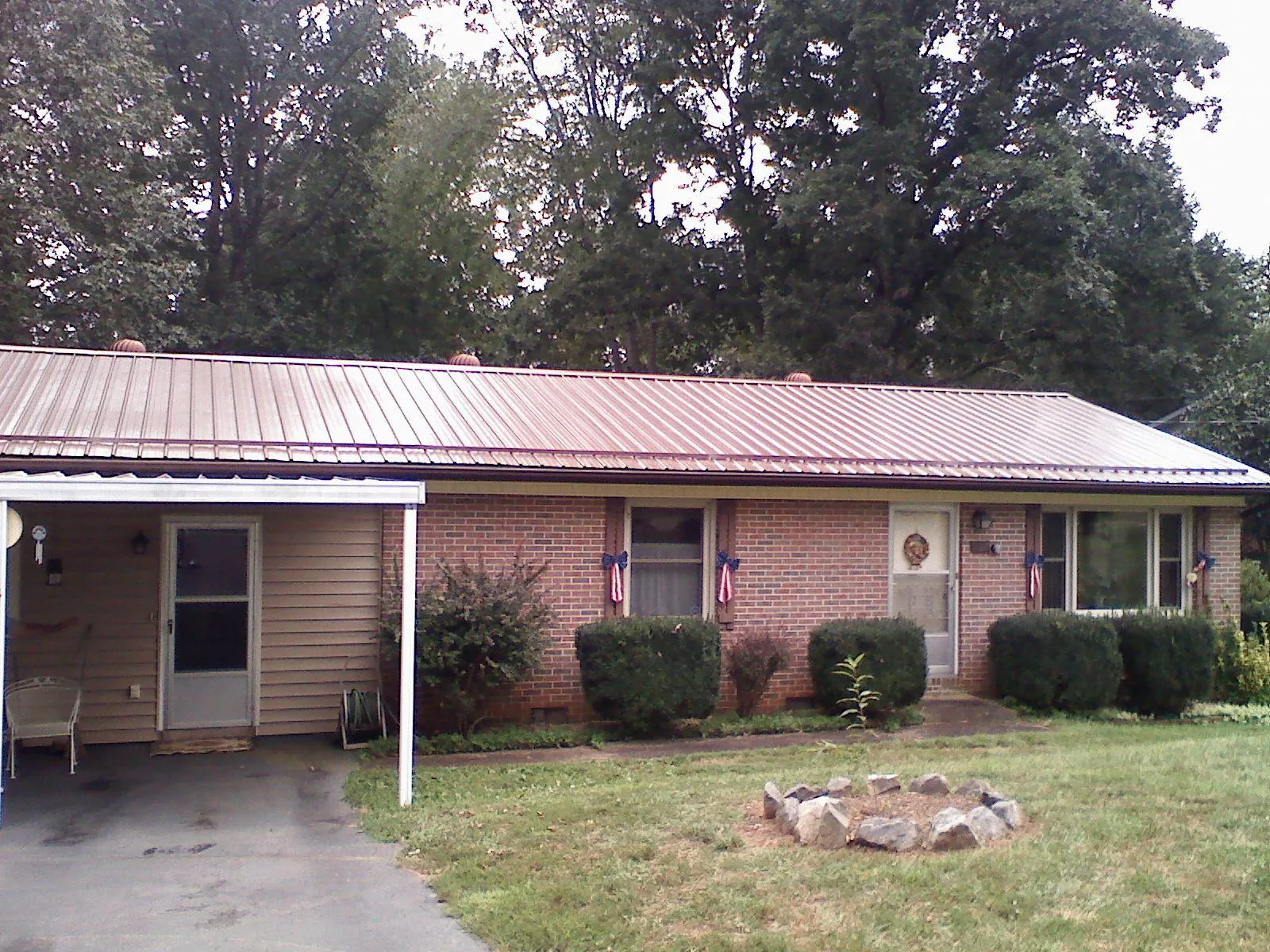 Bronze metal roof and carport on a brick ranch home — Roof Repair work by our crew in Haleyville