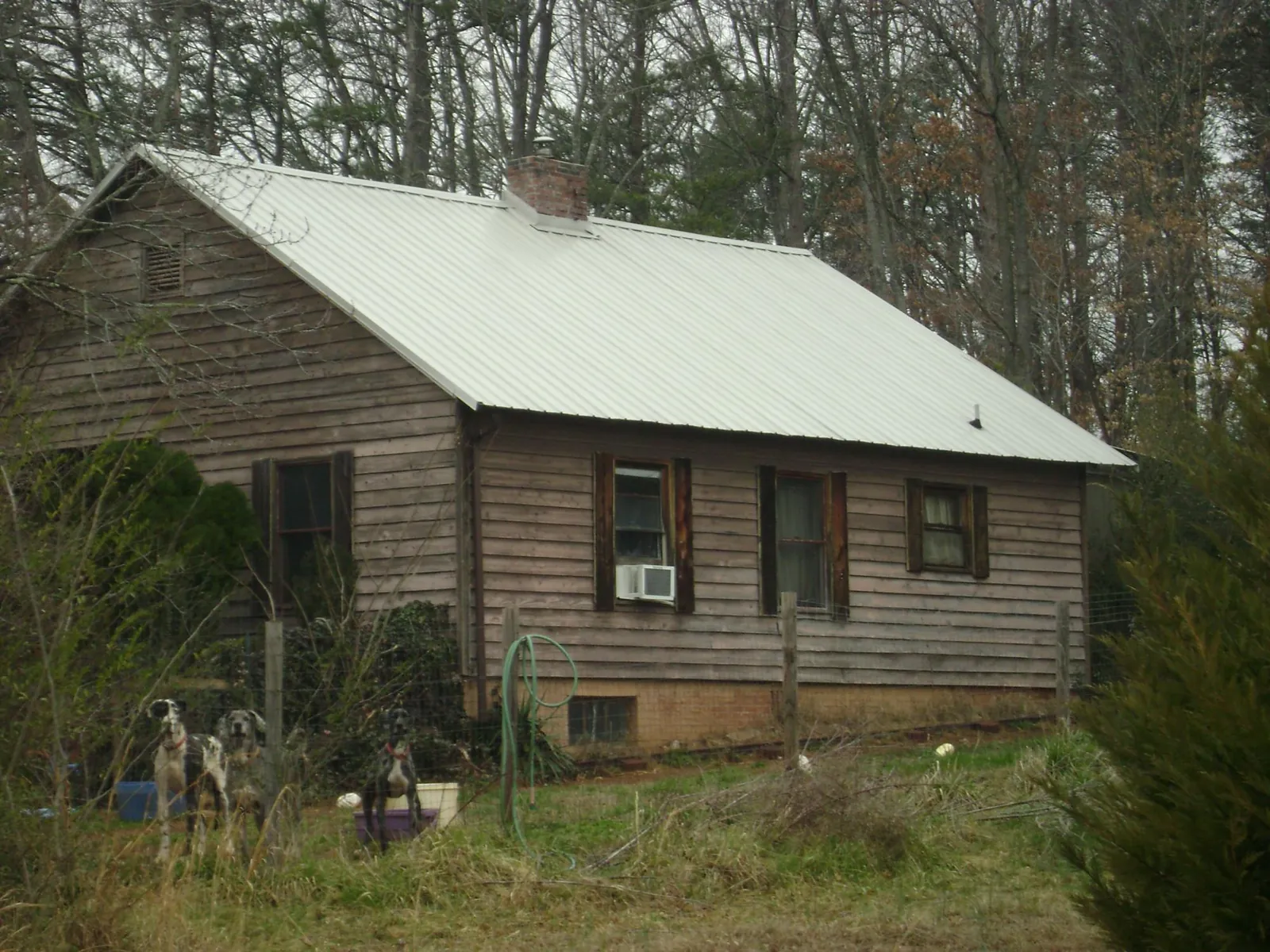 White metal roof on an old wood sided farmhouse, from a Metal Roof Installation job in Haleyville